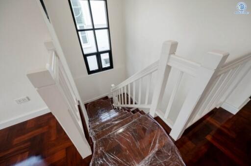 Elegant staircase with wooden floors and white bannister