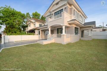 Elegant two-story house with large windows and well-kept lawn