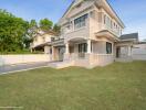 Elegant two-story house with large windows and well-kept lawn