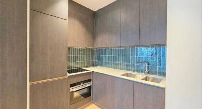 Modern compact kitchen with wooden cabinetry and blue tiled backsplash