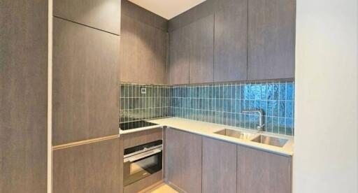 Modern compact kitchen with wooden cabinetry and blue tiled backsplash