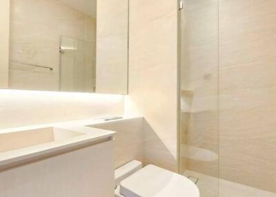 Modern bathroom with clean design featuring a large mirror and glass shower enclosure