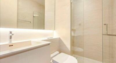 Modern bathroom with clean design featuring a large mirror and glass shower enclosure