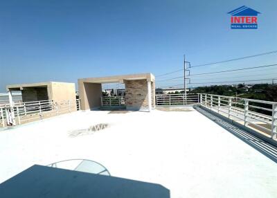 Spacious rooftop terrace with an open sky view and partial shade structure