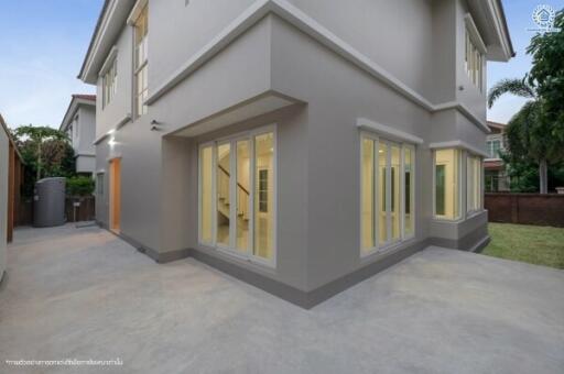 Modern two-story house exterior with illuminated windows and spacious courtyard