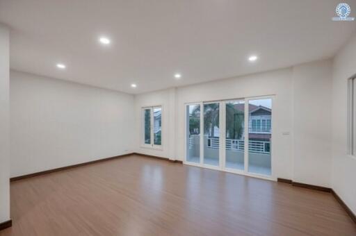 Spacious empty living room with large windows and wooden flooring