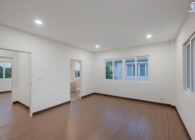 Spacious and well-lit empty bedroom with wooden floors