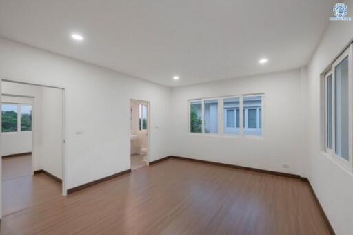 Spacious and well-lit empty bedroom with wooden floors