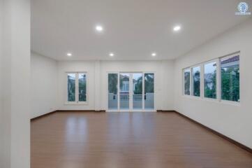 Spacious empty living room with hardwood floors and ample natural light