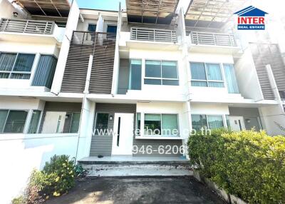 Modern multi-story townhouses with bright facade and shaded windows