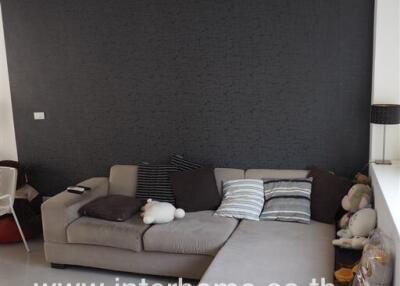 Spacious modern living room with large L-shaped sofa and statement dark wall
