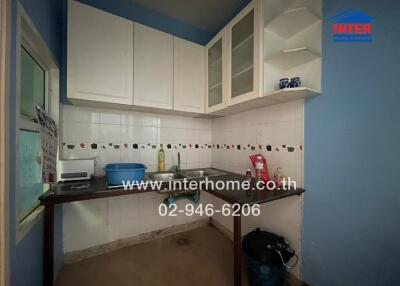 Compact kitchen space with white cabinetry and tiled backsplash