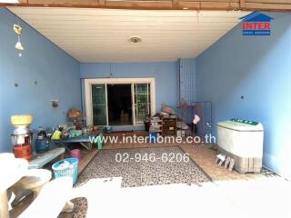 Spacious covered patio area with blue accents and household items