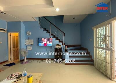 Spacious living room with staircase and vibrant blue walls