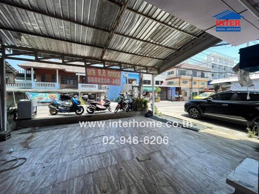 Covered parking area with motorcycles and a car, well-maintained and spacious