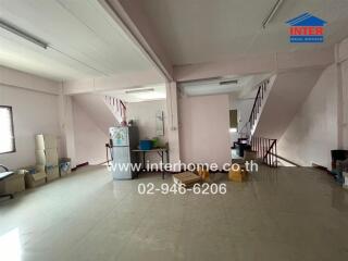 Spacious multi-purpose room with staircase and kitchen area