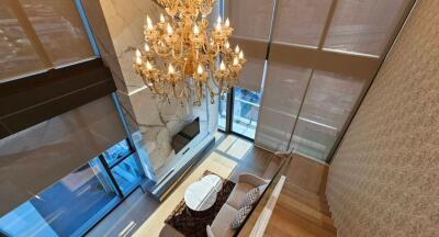 Luxurious double-height living room with chandelier and modern furniture