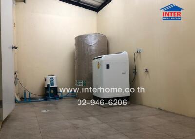 Utility room with large water storage tanks and equipment in a residential building