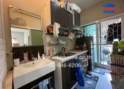 Cluttered kitchen interior with sink and storage