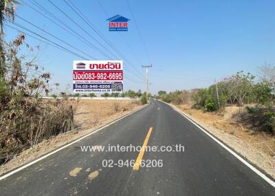 Asphalt road with real estate advertising billboard in a rural setting