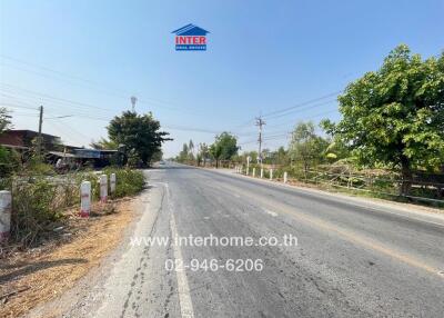 Rural road with surrounding trees and clear blue sky