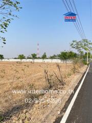 Empty land plot near road with company sign for real estate development