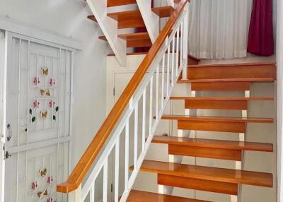 Bright and well-maintained wooden staircase with white railings inside a home
