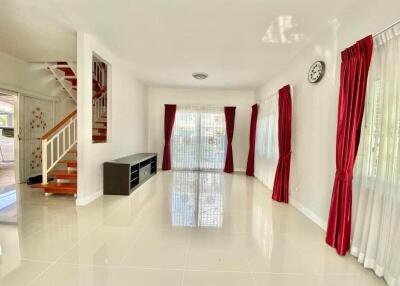 Spacious living room with red curtains and staircase