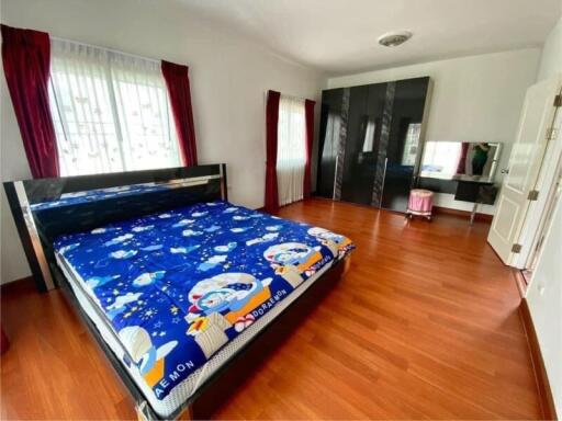 Spacious bedroom with large bed and wooden flooring