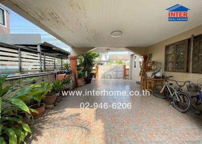 Spacious outdoor patio with shaded area, plants, and ample space for parking and bicycles