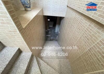 Interior staircase showcasing brick walls and tiled steps