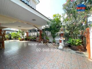 Spacious tiled patio with roof cover and decorative plants