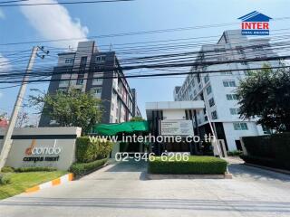 Exterior view of a modern condominium entrance with logo and contact information