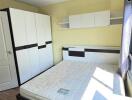 Bright and modern furnished bedroom with spacious wardrobe and large window