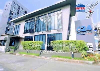 Modern commercial building exterior with large windows and prominent real estate signage