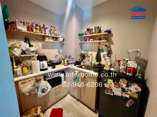 Cluttered small kitchen with multiple appliances and utensils