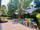 Leafy outdoor space with comfortable seating next to a building and greenery