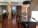 Modern kitchen with dining area featuring wooden flooring, state-of-the-art appliances, and ample natural light