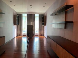 Spacious living room with hardwood floors and modern shelving