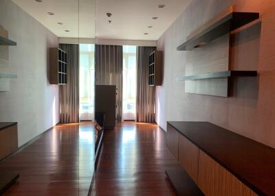 Spacious living room with hardwood floors and modern shelving