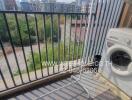 Washing machine and drying rack on a small urban balcony overlooking a construction site