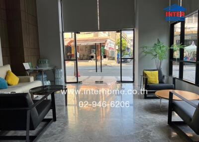 Modern lobby area with large glass doors, comfortable seating, and indoor plants