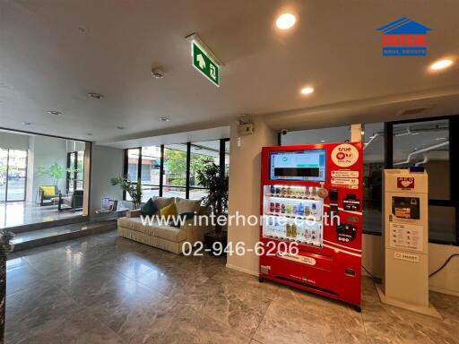 Spacious lobby area with seating and a vending machine