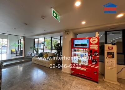 Spacious lobby area with seating and a vending machine