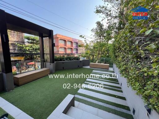 Well-maintained backyard with artificial grass and modern seating area