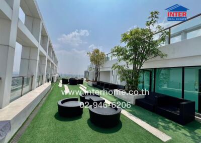Spacious rooftop patio with modern seating and green artificial grass