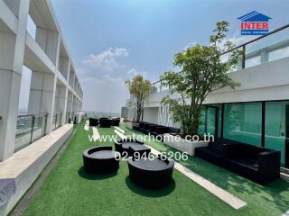 Spacious rooftop patio with modern seating and green artificial grass