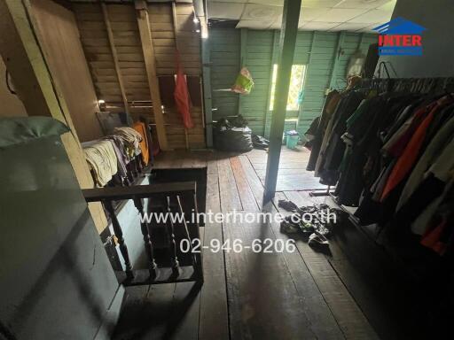 Dimly lit bedroom with clothing racks and wooden details