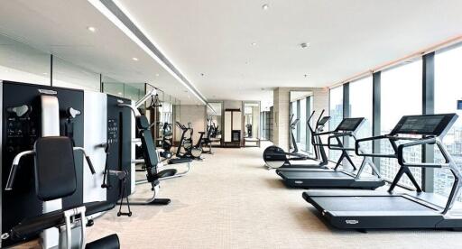 Modern gym with various exercise equipment and city views