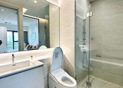 Modern bathroom interior with a glass shower, bath tub, and large mirror